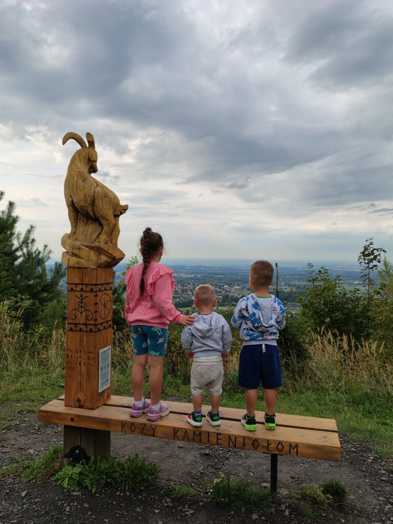 Dzieci stojące na dużej ławce w kaniełomie w Kozach.